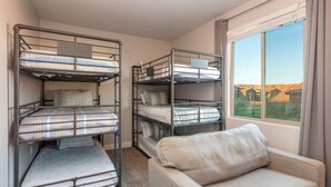 A room with bunk beds, a sofa, and a window with a view. - Paradise Retreat 94 & 96 | Neighboring Homes, Kid Friendly w/ Hot Tub's, Private Pool, Game Stations (Santa Clara)