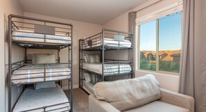 A room with bunk beds, a sofa, and a window with a view. - Paradise Retreat 94 & 96 | Neighboring Homes, Kid Friendly w/ Hot Tub's, Private Pool, Game Stations (Santa Clara)