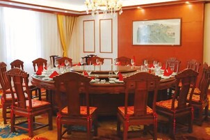 Un salón de conferencias con una mesa redonda, sillas y un candelabro.