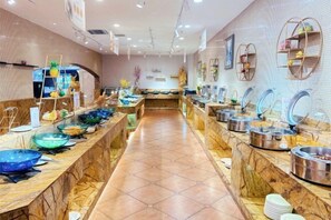 Een buffetopstelling met meerdere bedieningspunten, een lange toonbank en een betegelde vloer.
