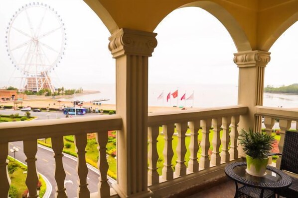 A balcony with a view of a Ferris wheel and a body of water. - Jintian International Hotel (Suqian)