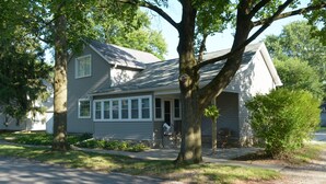 Ein eingeschossiges Haus mit Veranda, Garage und Auffahrt.