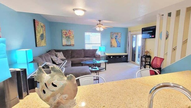 A living room with a sofa, coffee table, and artwork on the walls.