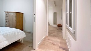 A bedroom with a bed, a wooden wardrobe, and a mirror. - UR-NEST San Giorgio - gorgeous flat (Bologna)