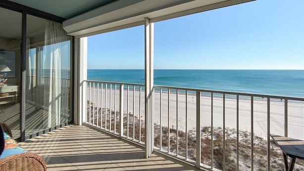 Un balcón con vista a la playa y al océano.