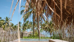A wooden deck leading to a pool with a view of palm trees and the ocean. - Zai Patacho (Porto de Pedras)
