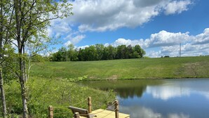A wooden dock extending into a calm pond, surrounded by lush greenery and trees. - Secluded 2 Bedroom Sanctuary on 20 Acres in the Heart of the Bourbon Trail (Chaplin)