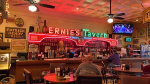 A bar with a neon sign reading "ERNIE'S Tavern" and a television screen displaying a sports event. - Secluded 2 Bedroom Sanctuary on 20 Acres in the Heart of the Bourbon Trail (Chaplin)