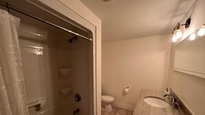 Un baño con ducha, inodoro y lavabo.