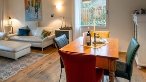 Una sala de estar moderna con una mesa de comedor de madera, un sofá y un cuadro en la pared.