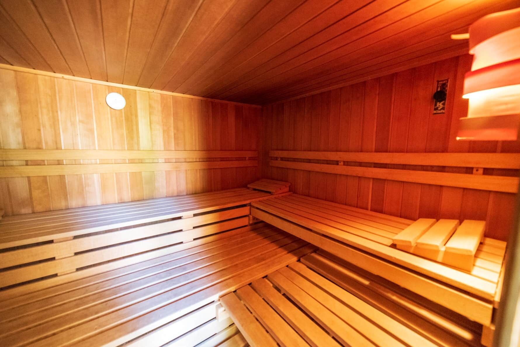 Una sauna con bancos de madera y suelo inclinado.