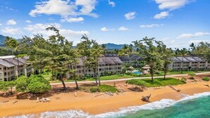 A beachfront hotel with multiple buildings, a sandy beach, and clear turquoise waters. - Islander on the Beach ONE-BEDROOM unit #308, Top floor, incredible Ocean Views (Kapaʻa)