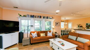 A living room with a sofa, a coffee table, and a television. - Dragonfly-Private Setting w/ Easy Beach Access; Covered & Screened Porch;TV/WiFi (Edisto Beach)