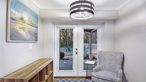 Ein moderner Eingangsbereich mit einer Bank, einem gemusterten Sessel und einem großen Gemälde an der Wand.