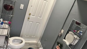A bathroom with a toilet, sink, and a shower area.
