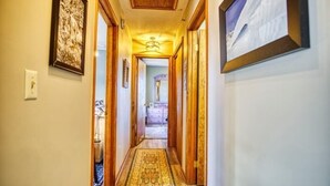 A hallway with a patterned carpet, wooden doors, and framed artwork on the walls. - C302-Great views of lift! Slopeside Condo, pets OK! (Davis)