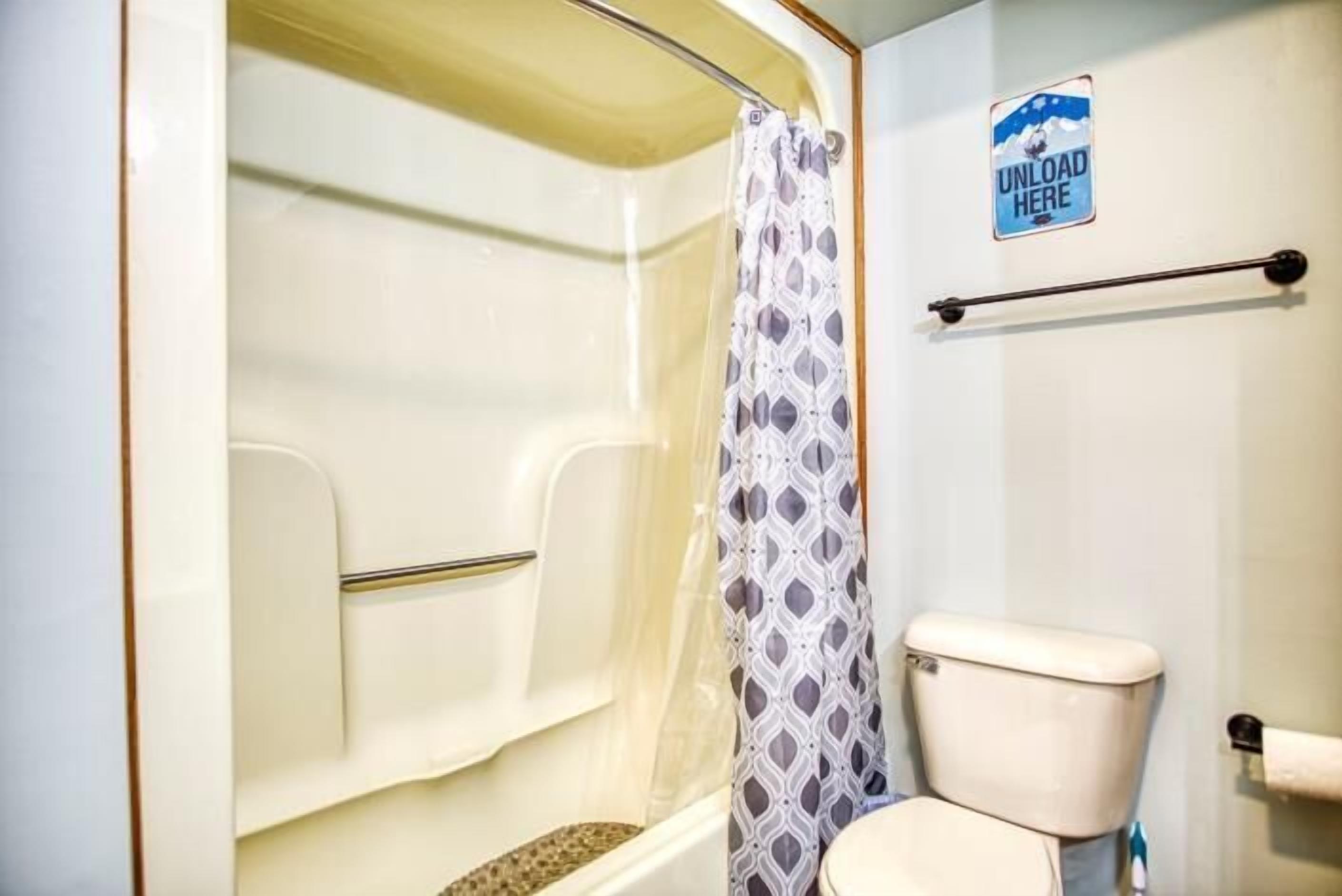 Ein Badezimmer mit Dusche, Toilette und Handtuchhalter.