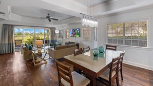 A spacious living room with a dining area, large windows with blinds, a chandelier, and a ceiling fan. - Centre Court Cay: Water Park, Golf View, Pool, Near Disney (Kissimmee)