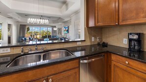 A modern kitchen with wooden cabinets, stainless steel sinks, and a coffee maker. - Centre Court Cay: Water Park, Golf View, Pool, Near Disney (Kissimmee)