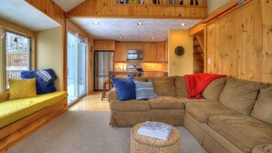 Una sala de estar acogedora con un sofá modular, una mesita de centro y un asiento junto a la ventana.