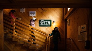 Una escalera de madera en el interior de un edificio, con un letrero que dice "PUB AT SADDLEBACK".