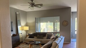Un salon avec un canapé, une table basse et un ventilateur de plafond.