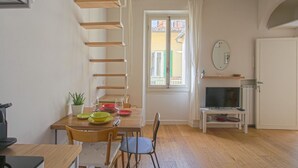 Comedor con mesa de madera, sillas y ventana con cortinas.