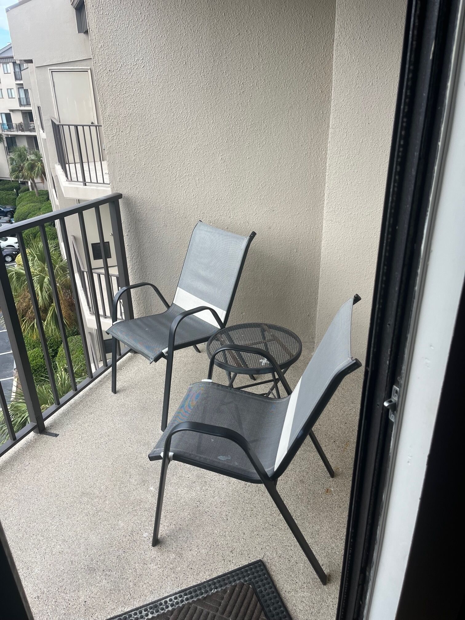 Ein Balkon mit zwei Stühlen und einem kleinen Tisch.