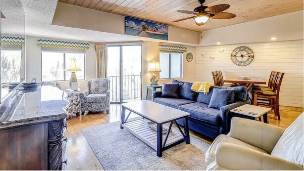 A spacious living area with a wooden ceiling, a bar area, and a dining set.