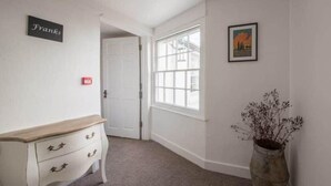 A room with a white dresser, a large window, a door, and a framed picture on the wall. - Franks- 2nd Floor Apt-2 Bath-Cowes Centre-Sleeps 4 (Isle of Wight)