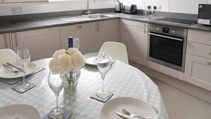 A modern kitchen with white cabinets, a stainless steel oven, and a window providing natural light. - Franks- 2nd Floor Apt-2 Bath-Cowes Centre-Sleeps 4 (Isle of Wight)