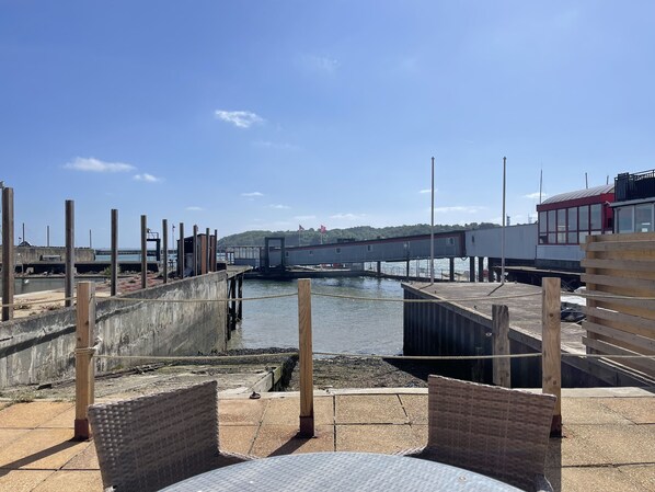 Un muelle frente al agua con postes de madera y un paseo de hormigón.