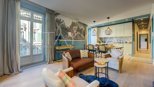 Un salón amplio con sofá, sillones y comedor.