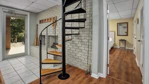 Een modern interieur met een wenteltrap, een bakstenen muur en een houten vloer.