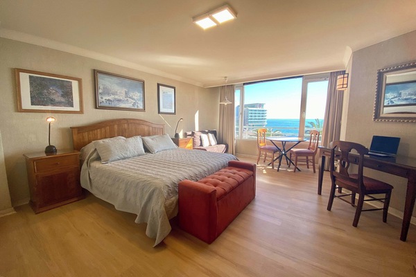 Studio with king bed, desk, dining nook and ocean view