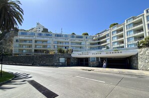 A multi-story hotel with balconies and a stone facade.