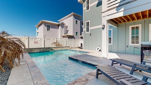 A swimming pool with a stone border, adjacent to a building with a white fence and a 'NO DIVING' sign. - Gulf Views, Private Heated Pool, Golf Cart Included, Boardwalk to the Beach (Port Aransas)