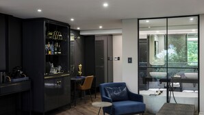 Una cocina moderna con armarios oscuros, un sofá azul y una mesa redonda.