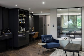 A modern kitchen with dark cabinetry, a blue sofa, and a round table. - Seven Villa Hotel and Spa (Johannesburg)