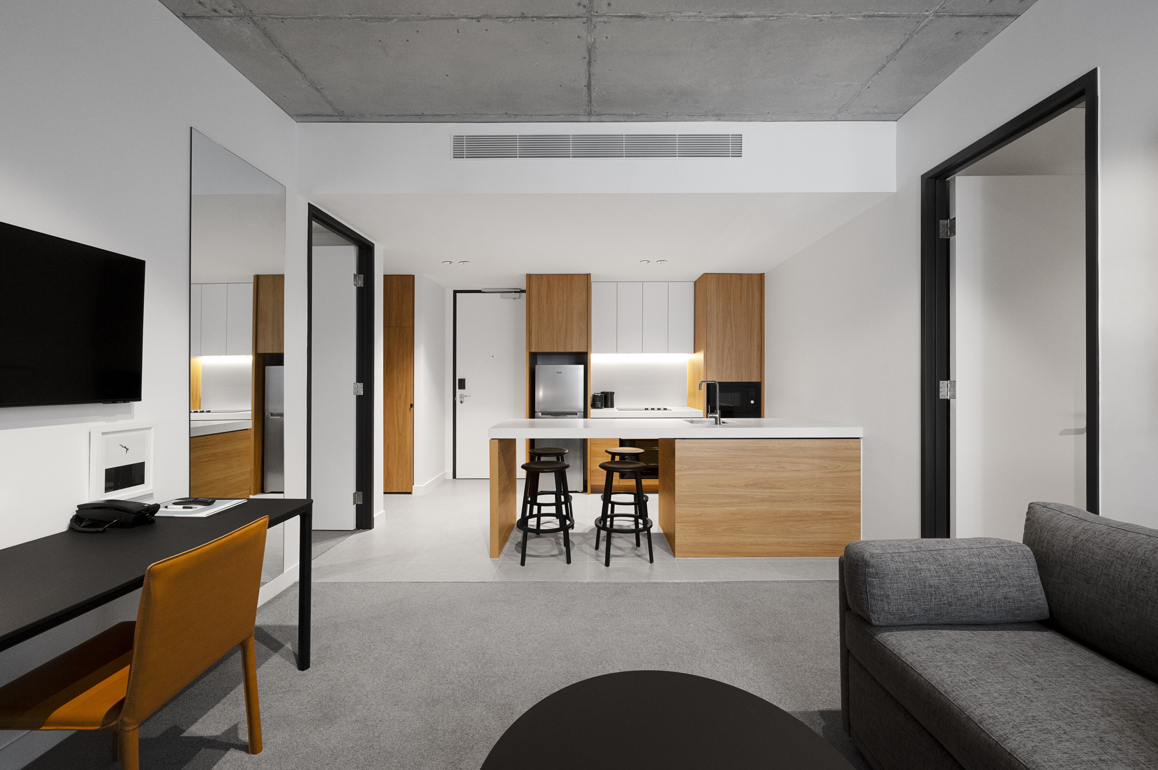 Una cocina moderna con una isla central, armarios de madera y un refrigerador empotrado.