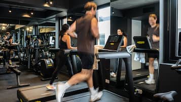 A gym with treadmills, exercise machines, and mirrors.