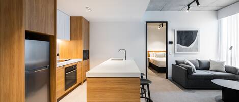 Una cocina moderna con armarios de madera, un refrigerador integrado y una isla central.
