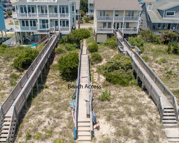 A beach access area with wooden walkways leading to beachfront properties.