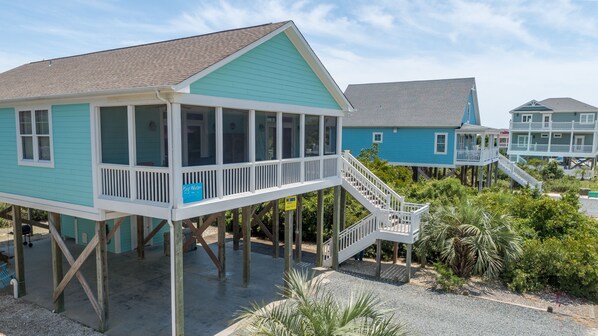 A coastal house with a balcony and a deck, featuring a 'Big Water' sign.