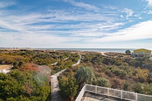 A coastal landscape with a pathway leading to a yellow building. - Coble Cottage - Beautiful views and a private pool in a private, gated community. (Holden Beach)