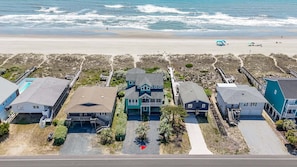 Zona residencial costera con casas, una playa y cielo despejado.