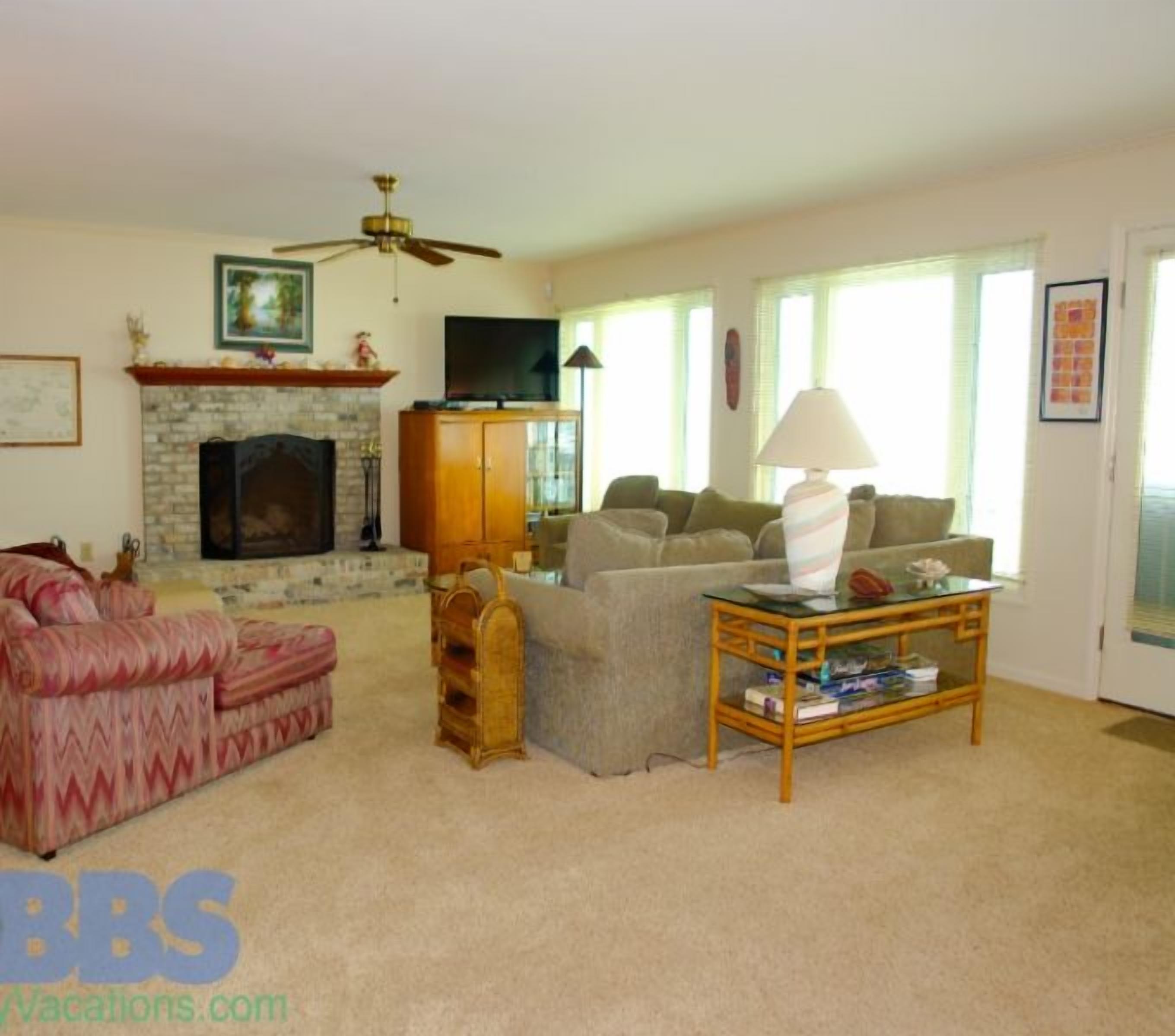A living room with a fireplace, a sofa, a coffee table, and a television.