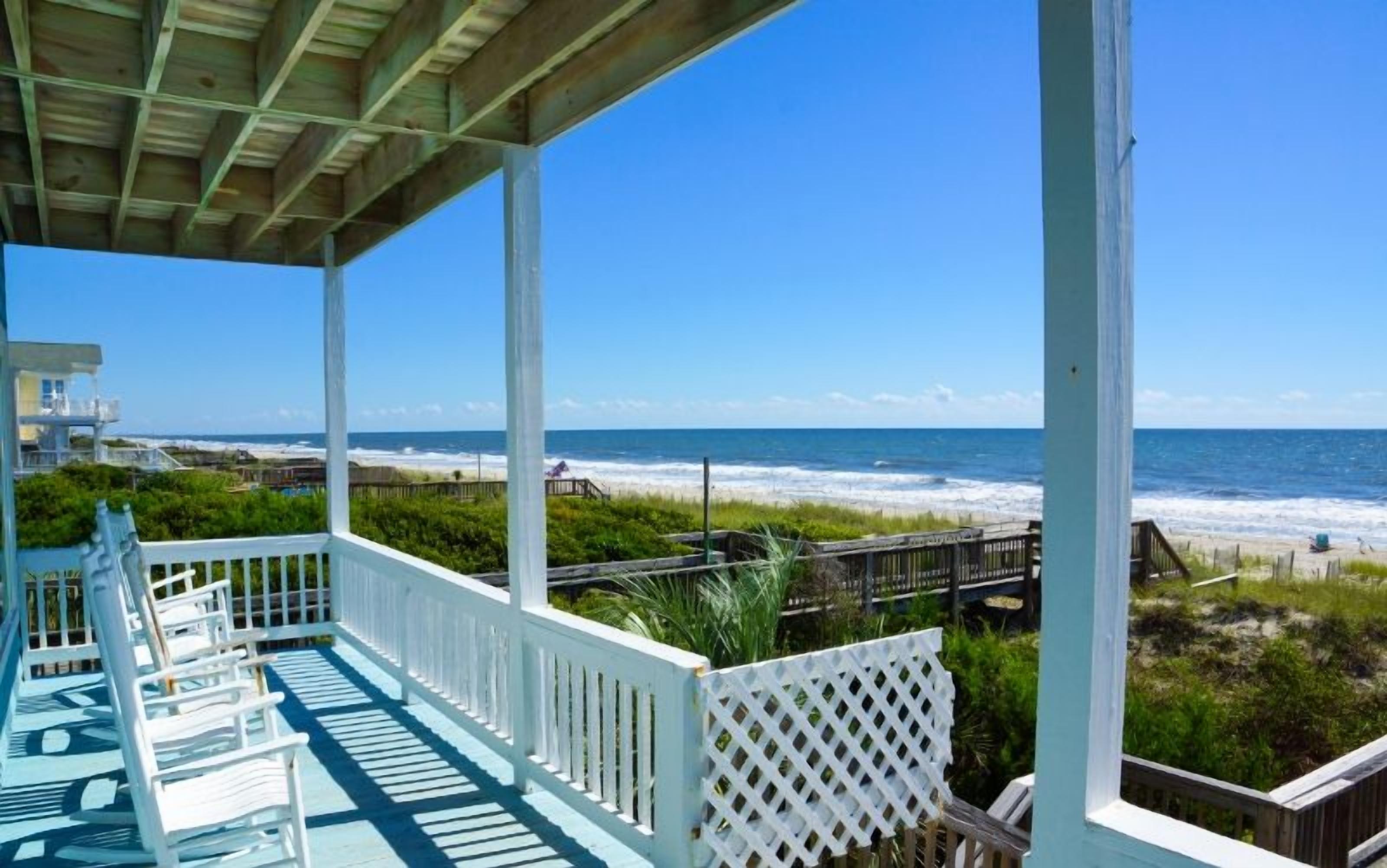Eine überdachte Terrasse mit Blick auf Strand und Meer.