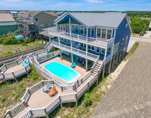 Una casa de varios pisos con una terraza grande y una piscina.