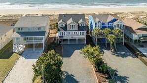 A beachfront property with multiple houses, a sandy beach, and the ocean in the background.